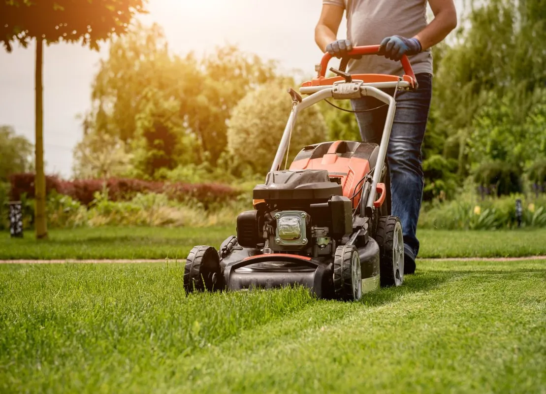 Gardener mowing the lawn. Landscape design.