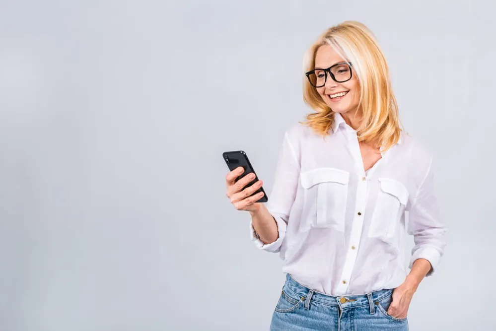 Happy,Mature,Senior,Woman,Holding,Smartphone,Using,Mobile,Online,Apps,