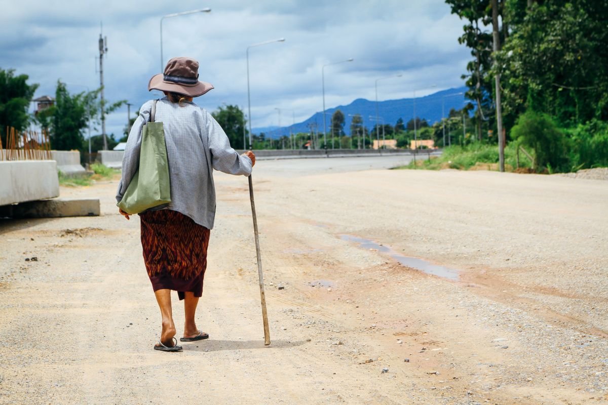 Asian,Elder,Woman,With,Hat,,Cane,And,Bag,Walking,Down