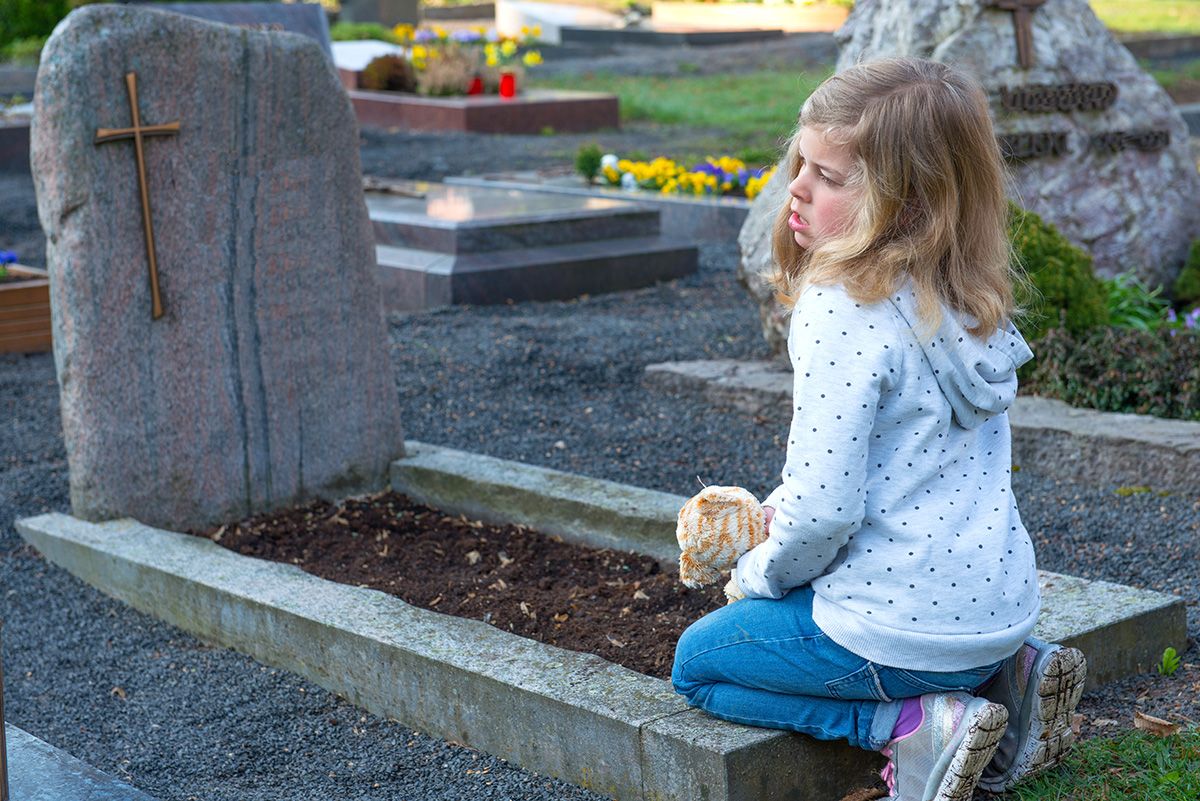 Little,Sad,Girl,In,Front,Of,Grave