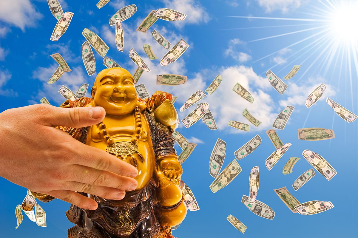 Feng,Shui.,Buddha,Against,A,Blue,Sky,With,Falling,Dollars.