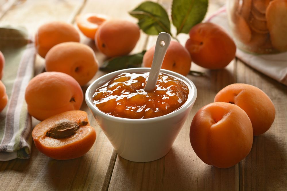 Apricot,Jam,In,White,Bowl,With,Fruit,Around,-,Closeup