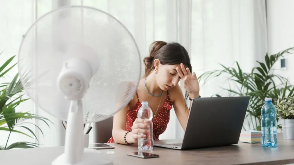 Woman,Sitting,At,Desk,At,Home,During,A,Summer,Heat