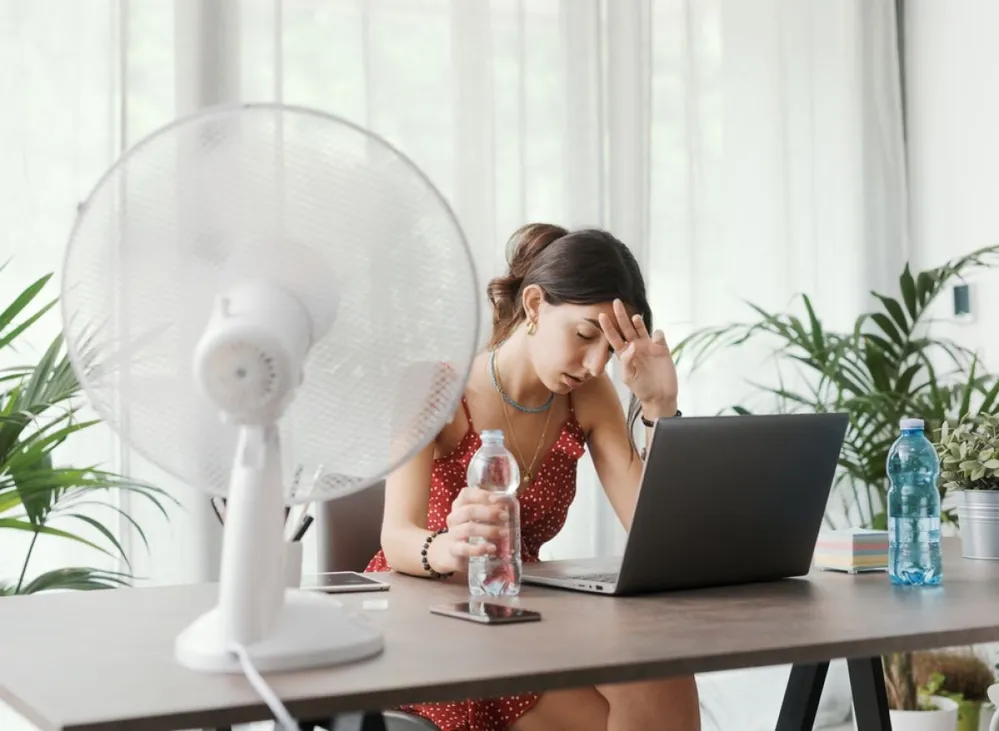 Woman,Sitting,At,Desk,At,Home,During,A,Summer,Heat