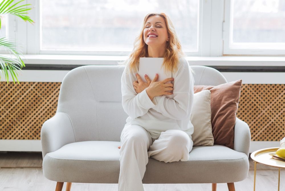 A,Woman,In,White,Clothes,Reads,On,The,Couch,At