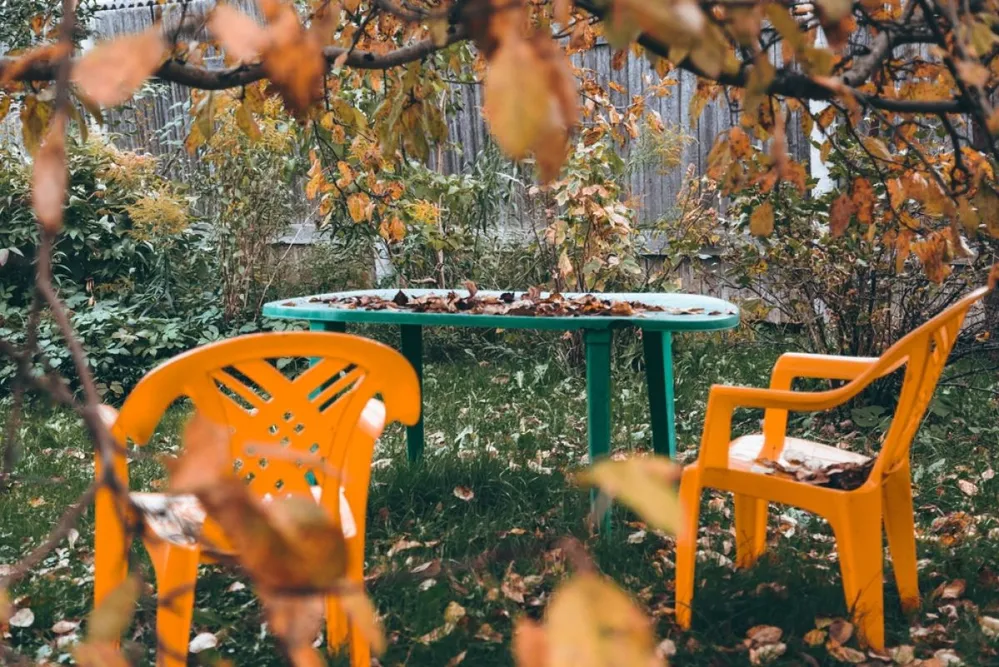 Two,Yellow,Plastic,Chairs,And,Green,Plastic,Table,Under,The