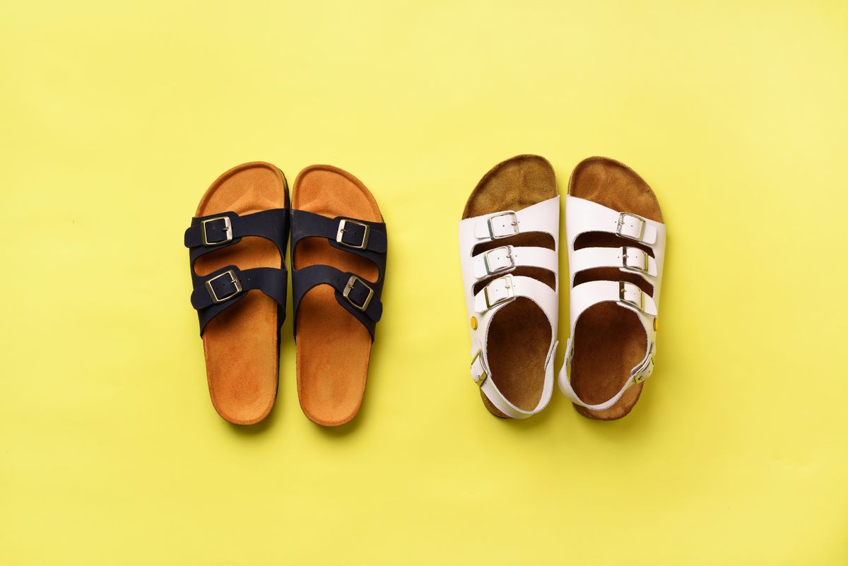 Summer female shoes - sandals (birkenstock) and slippers on yellow background with copy space. Top view. Minimal flat lay. Selection concept