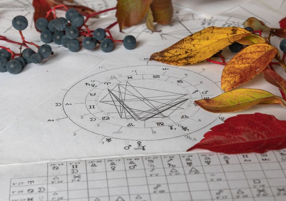 Printed,Astrology,Charts,With,Yelow,And,Autumn,Leaves,And,Blueberries