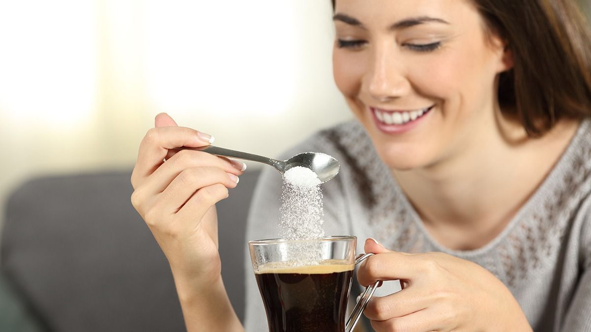 Close,Up,Of,A,Happy,Girl,Throwing,Sugar,Into,Coffee