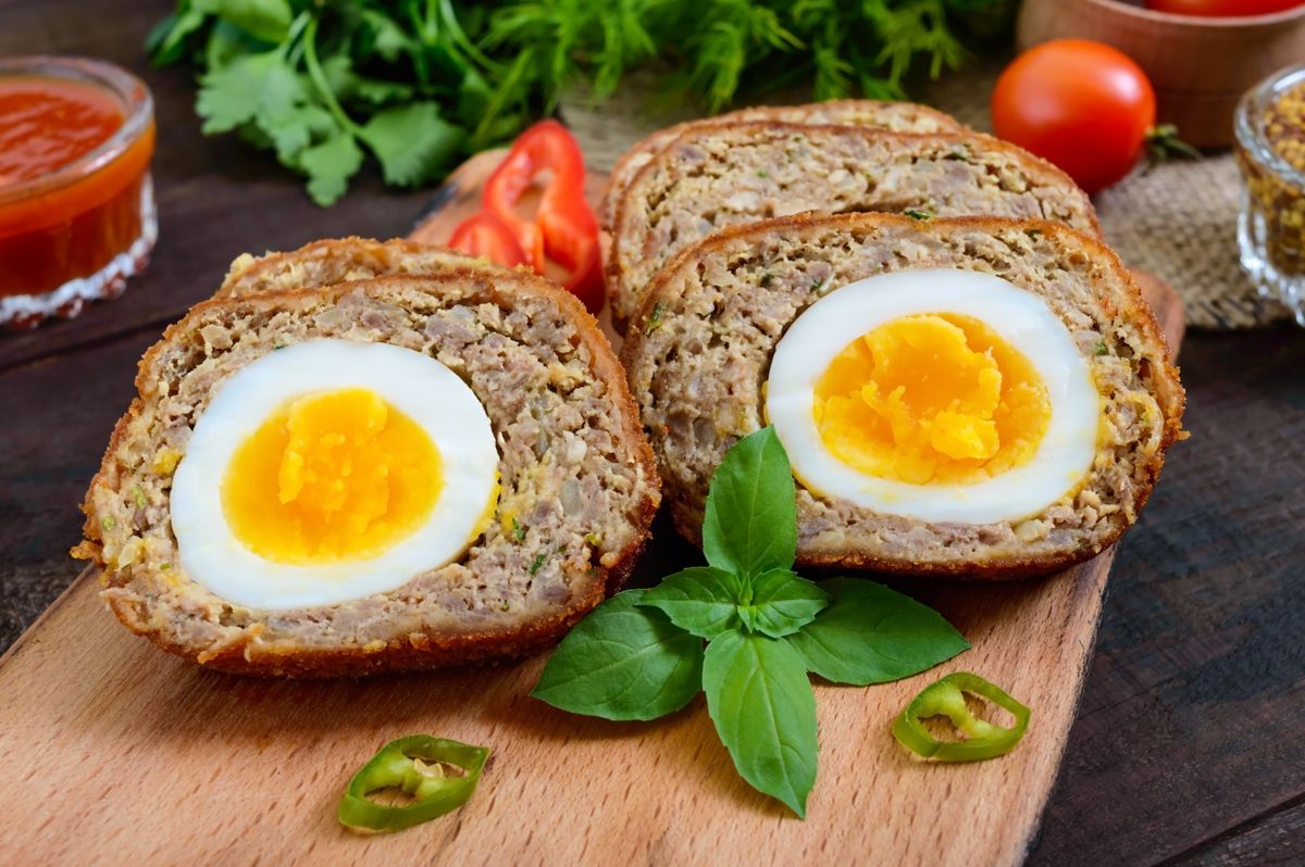 Meat,Cutlet,With,Boiled,Egg,,Pieces,On,A,Dark,Wooden