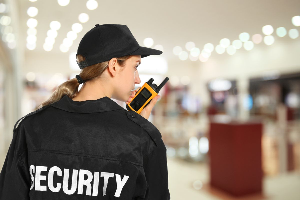 Security,Guard,Using,Portable,Radio,Transmitter,In,Shopping,Mall,,Space