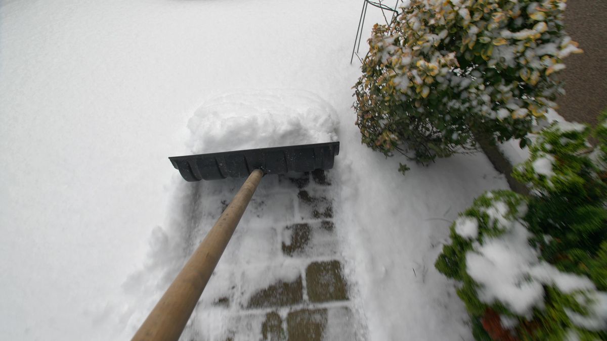Man,Clearing,Backyard,Pavement,Of,Snow,With,Snowshovel,Pov