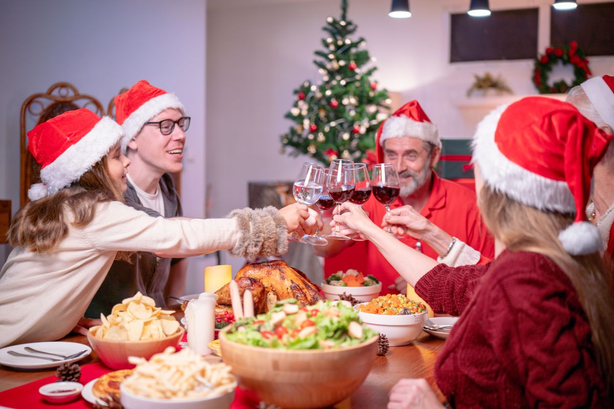Happy,Family,Wearing,Santa,Claus,Hat,Having,Christmas,Dining,At