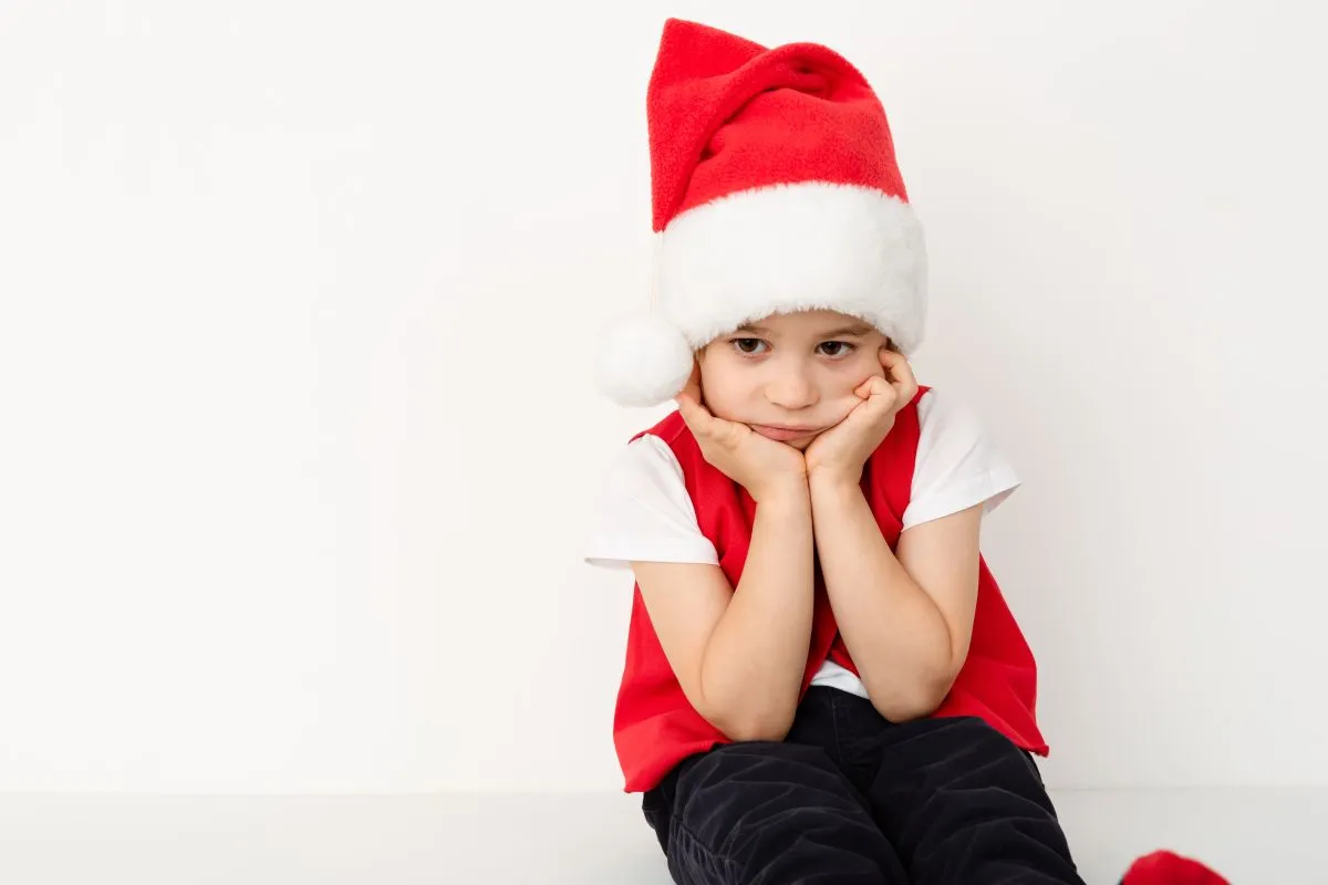 Portrait,Of,Sitting,Resentful,Little,Child,In,Red,Santa,Claus