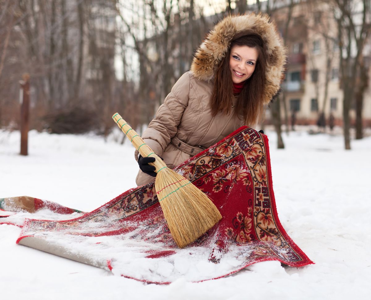 Happy,Woman,Cleans,Red,Carpet,With,Snow,In,Winter