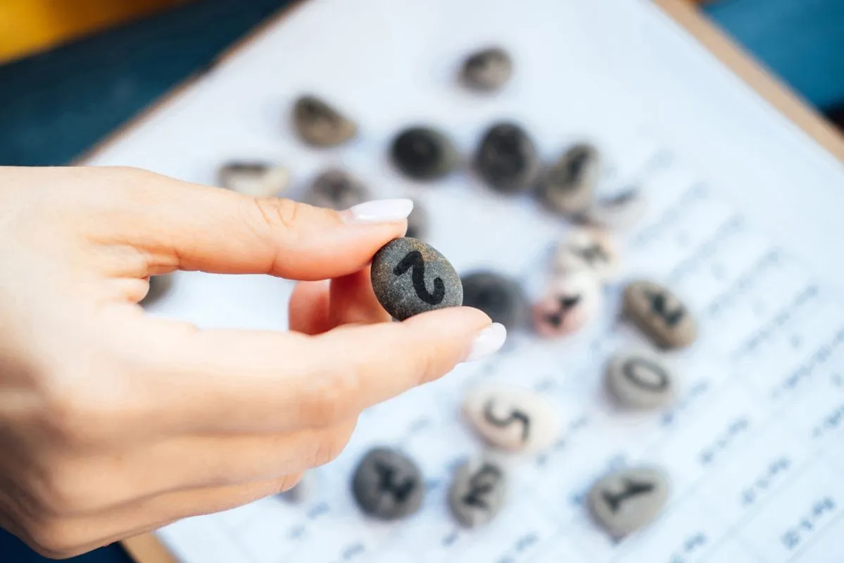 Woman,Numerologist,Hand,With,Pebble,Stone,With,Number,Two,2.