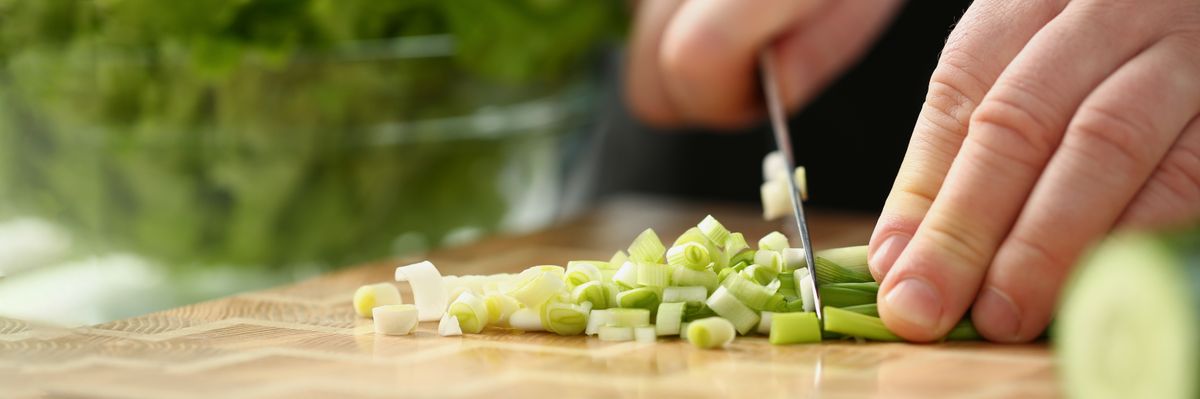 Professional,Chef,Cut,Spring,Onion,With,Sharp,Knife,On,Cutting