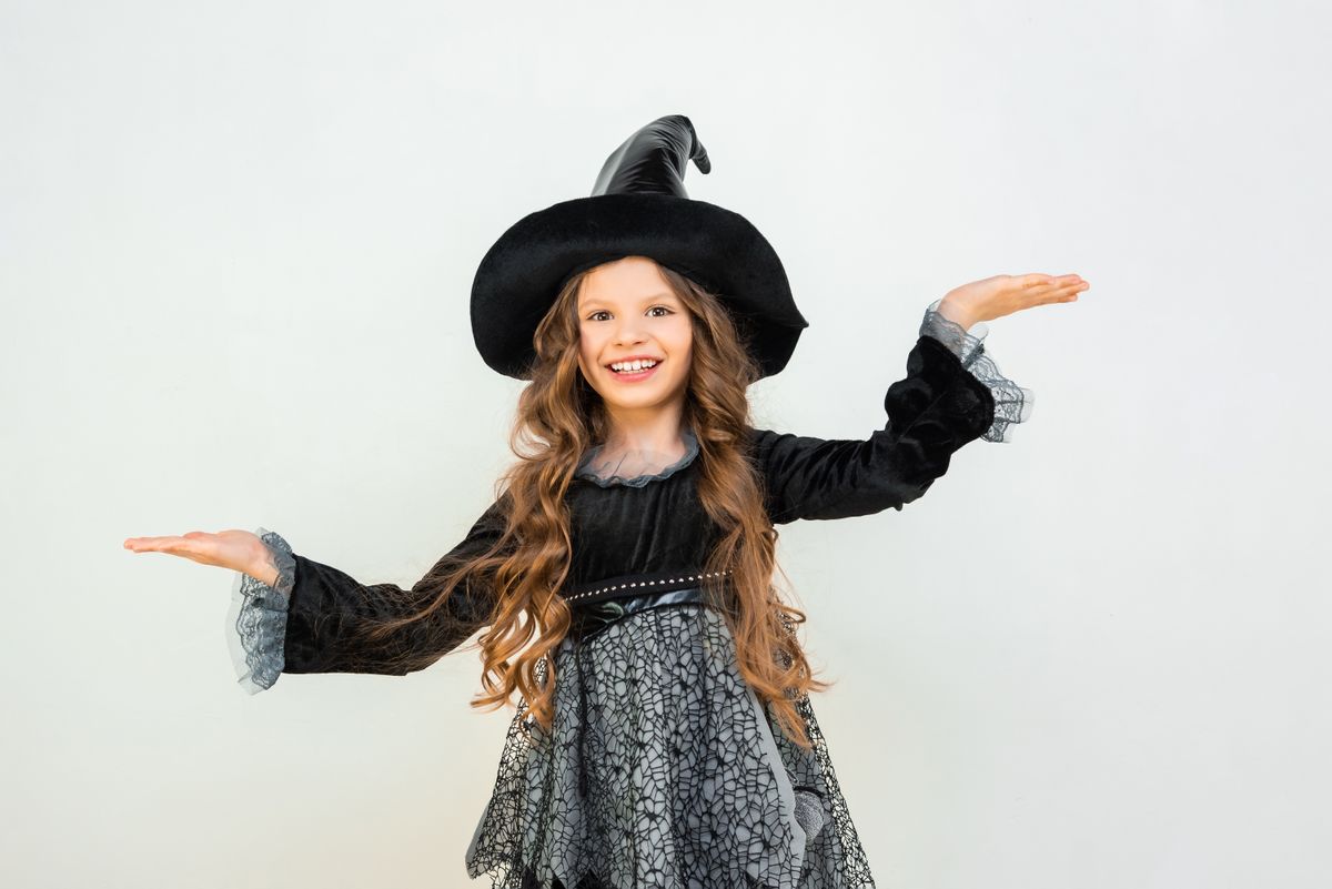 A,Little,Girl,In,A,Witch,Costume,Is,Dancing.,A
