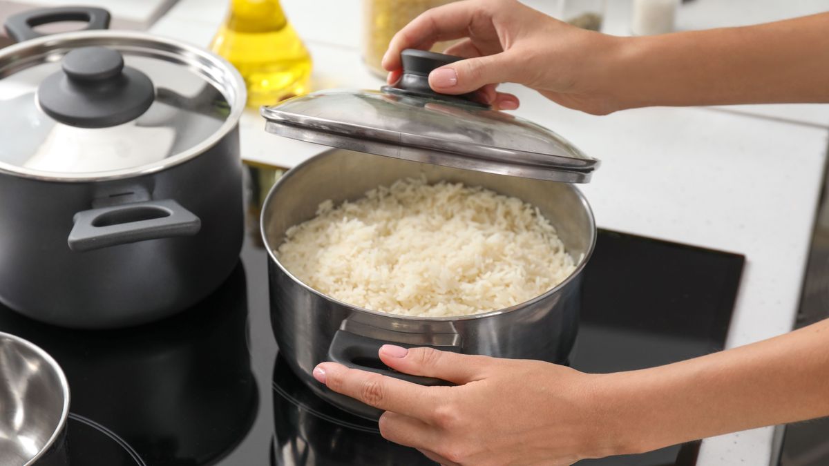 Woman,Cooking,Rice,On,Stove,In,Kitchen