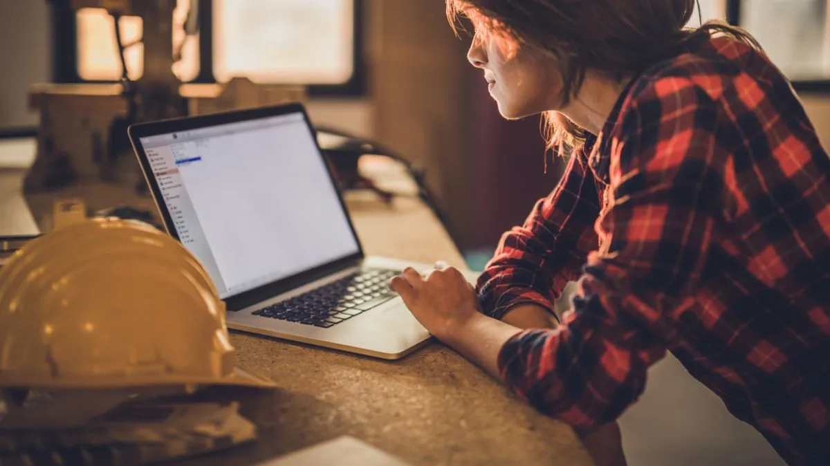 Female construction worker using laptop during home renovation process. laptop
