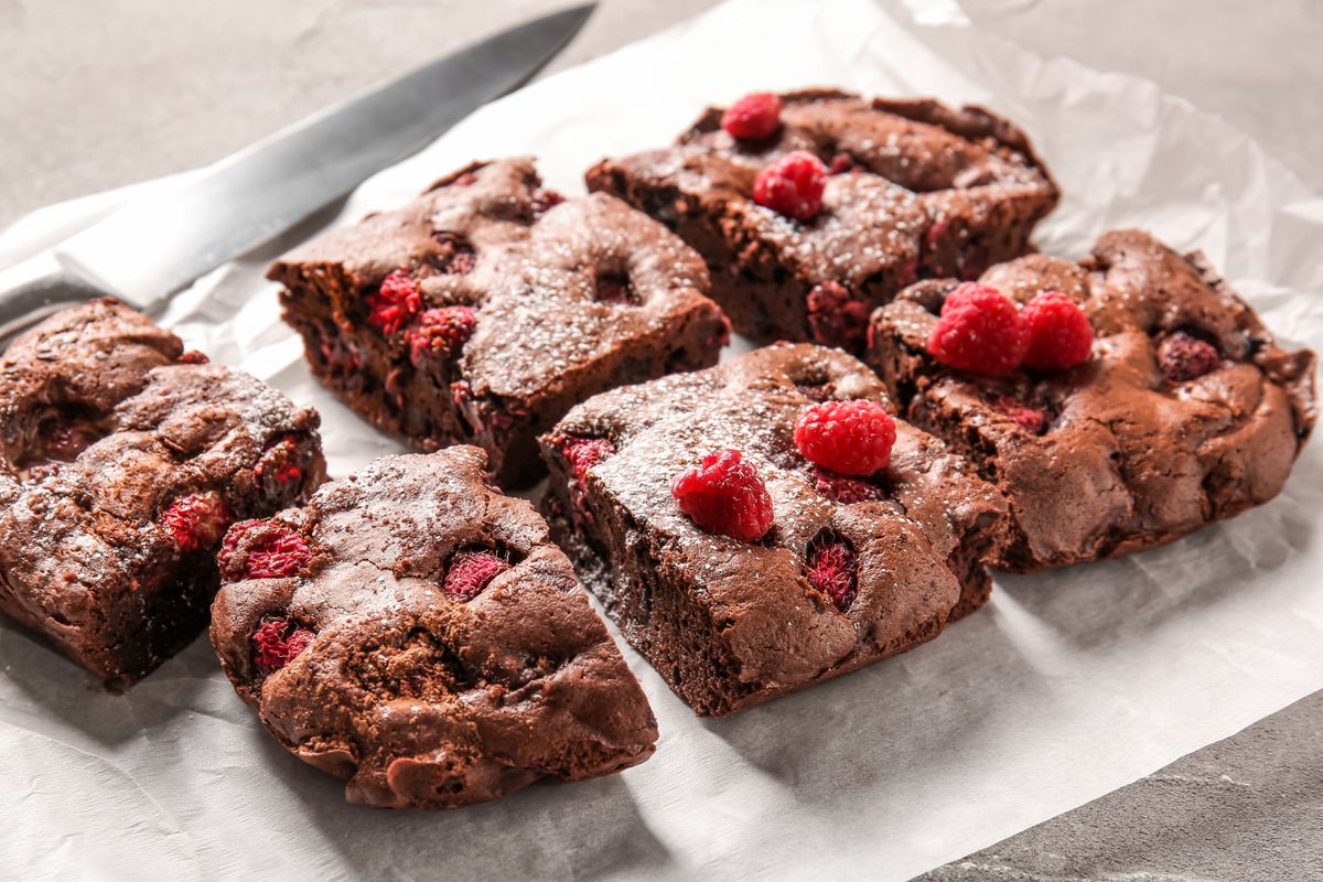 Baking,Paper,With,Pieces,Of,Raspberry,Chocolate,Brownie,On,Grey