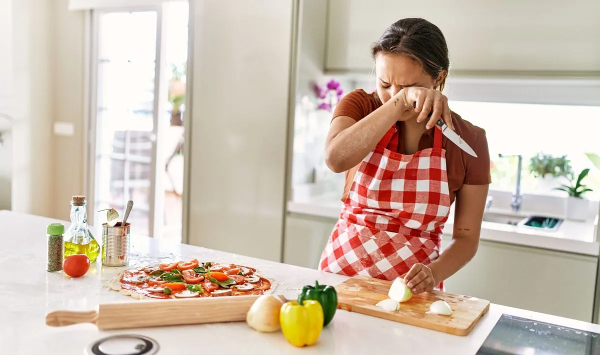Young,Beautiful,Hispanic,Woman,Cutting,Onion,Crying,At,The,Kitchen