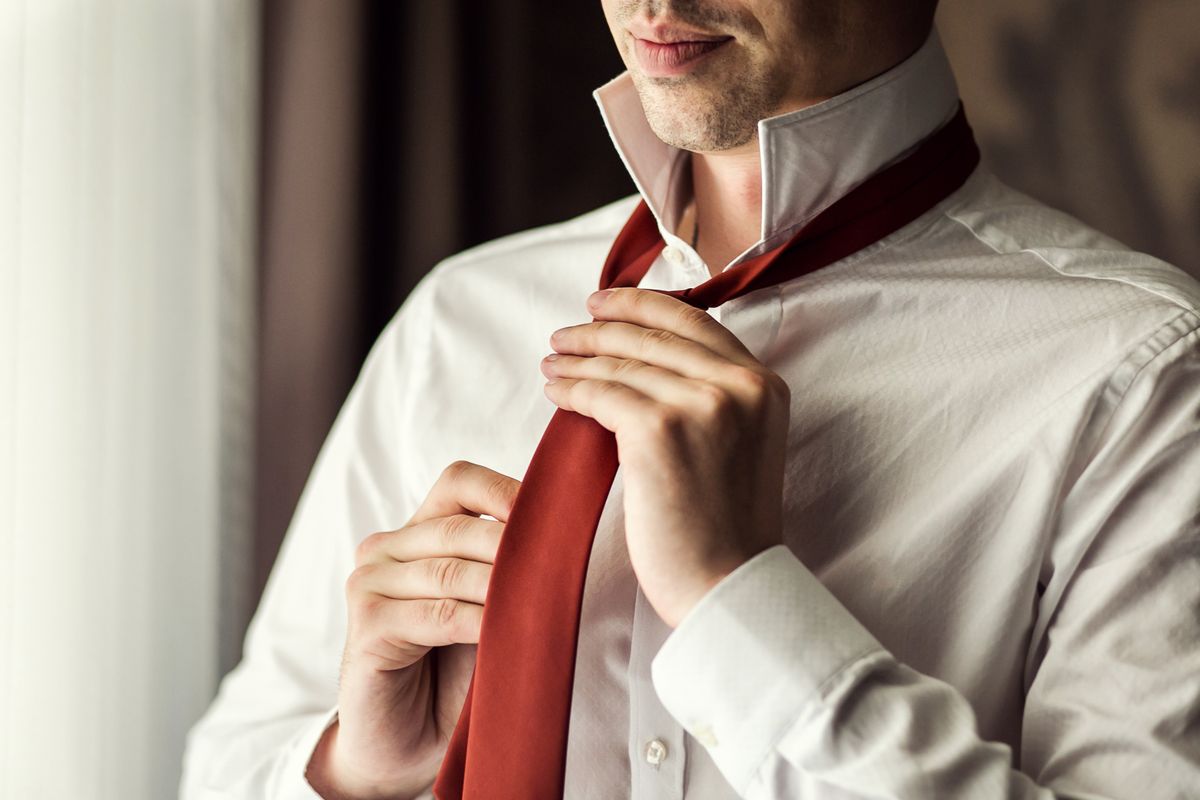 Man,In,Shirt,Dressing,Up,And,Adjusting,Tie,On,Neck