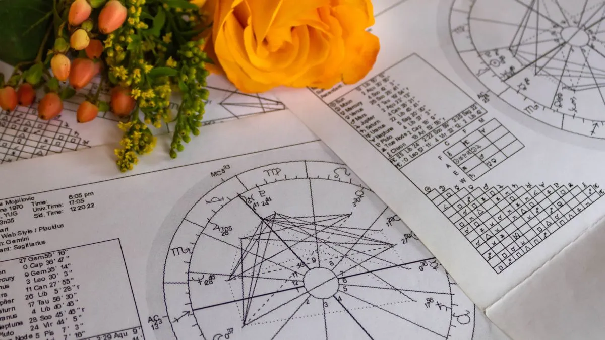 Printed,Astrology,Charts,With,Orange,Flowers,In,The,Background
