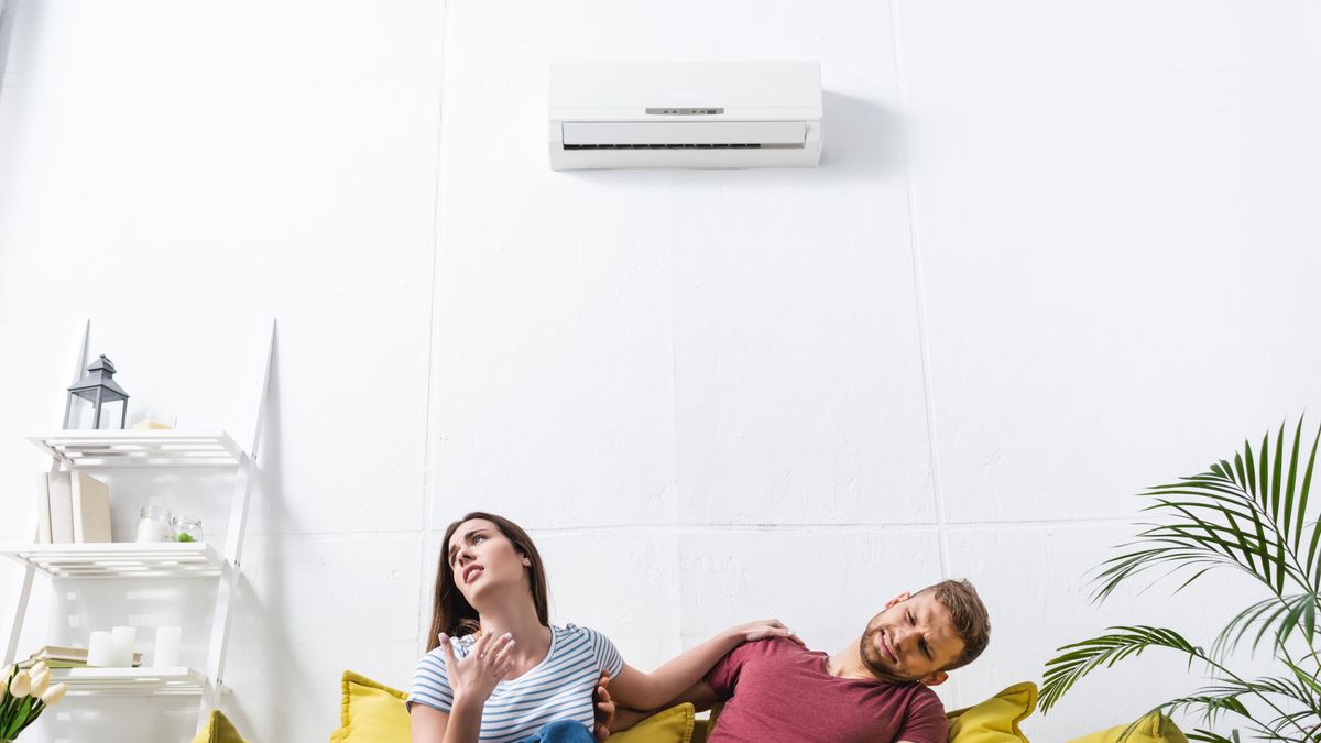 Angry,Couple,With,Remote,Controller,Suffering,From,Heat,At,Home