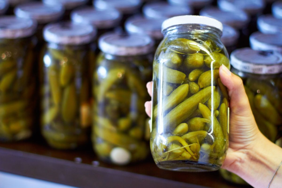 Woman,,Hand,And,Jar,Of,Pickles,In,Store,For,Product