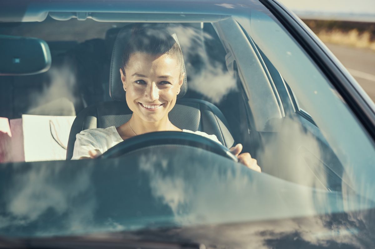 Happy,Woman,Driving,In,A,Car,And,Smiling