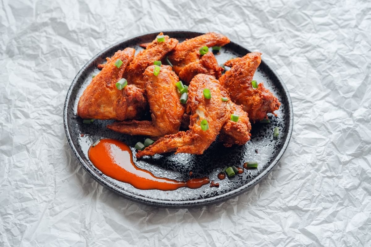 Crispy,Fried,Chicken,Wings,Topped,With,Spring,Onion,And,Tomato