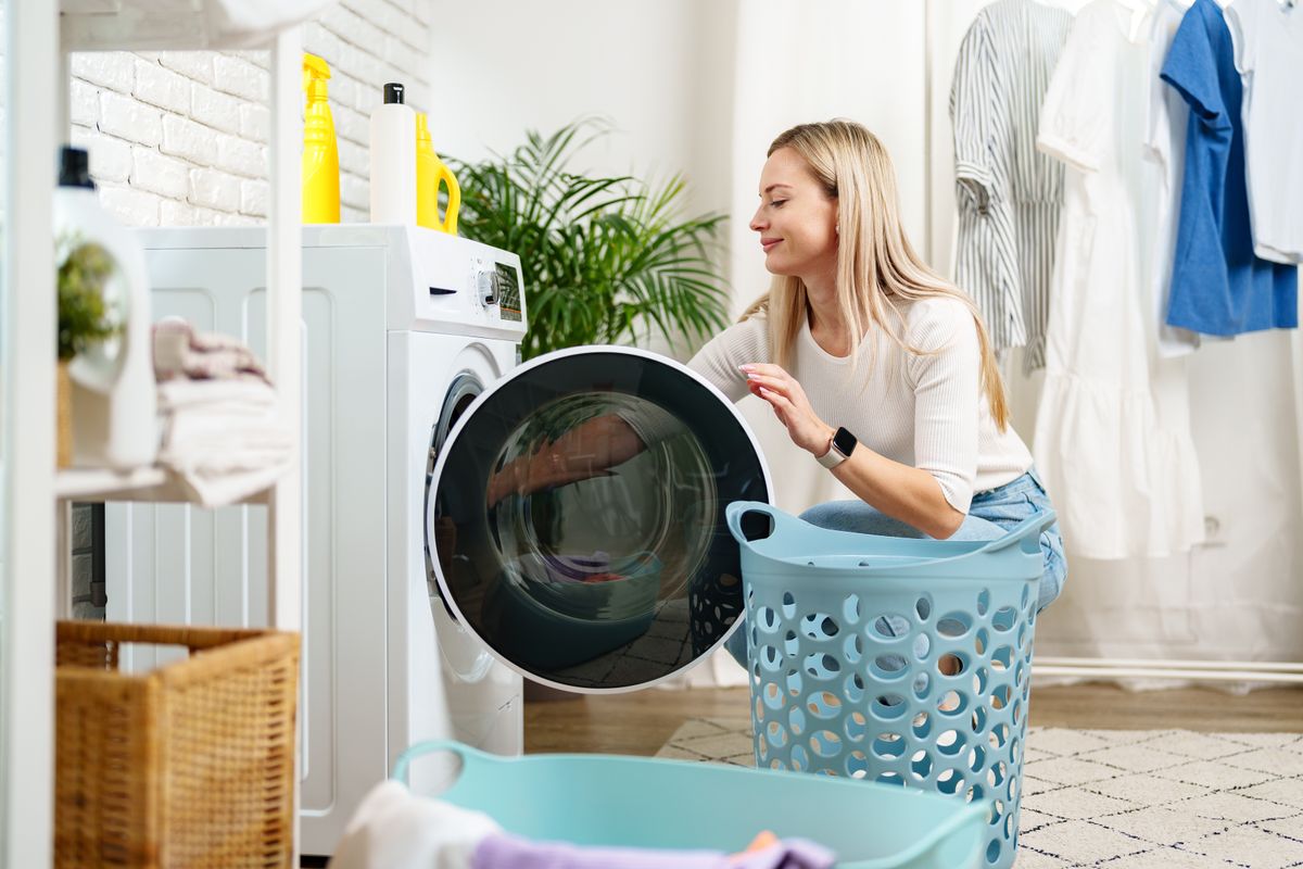 Woman,Doing,Laundry,Near,A,Washing,Machine