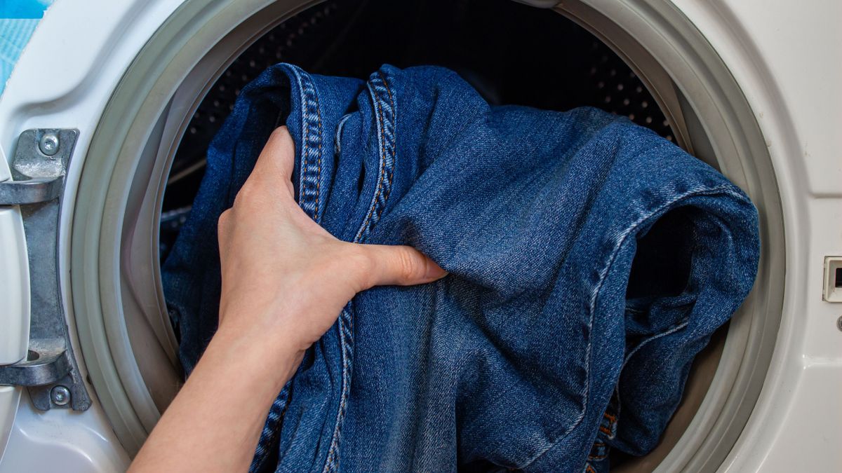 Woman,Is,Loads,The,Washing,Machine,With,Dirty,Clothes.