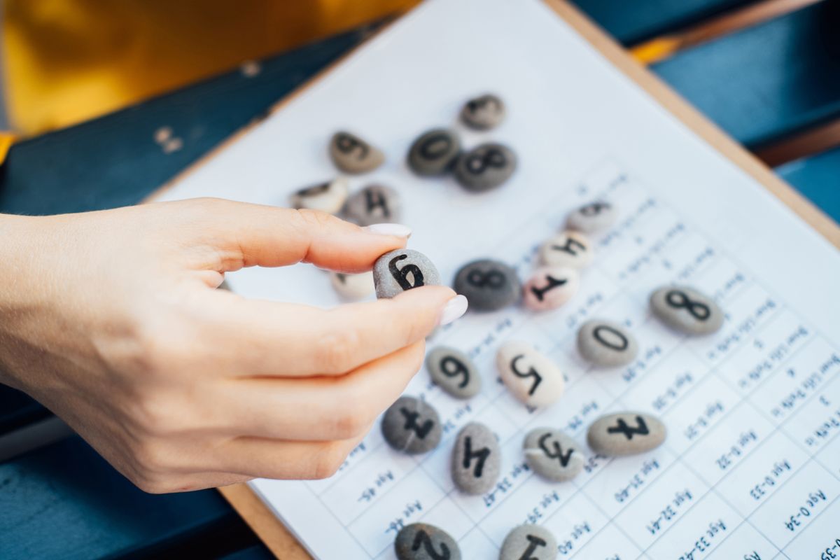 Woman,Numerologist,Hand,With,Pebble,Stone,With,Number,Nine,9.