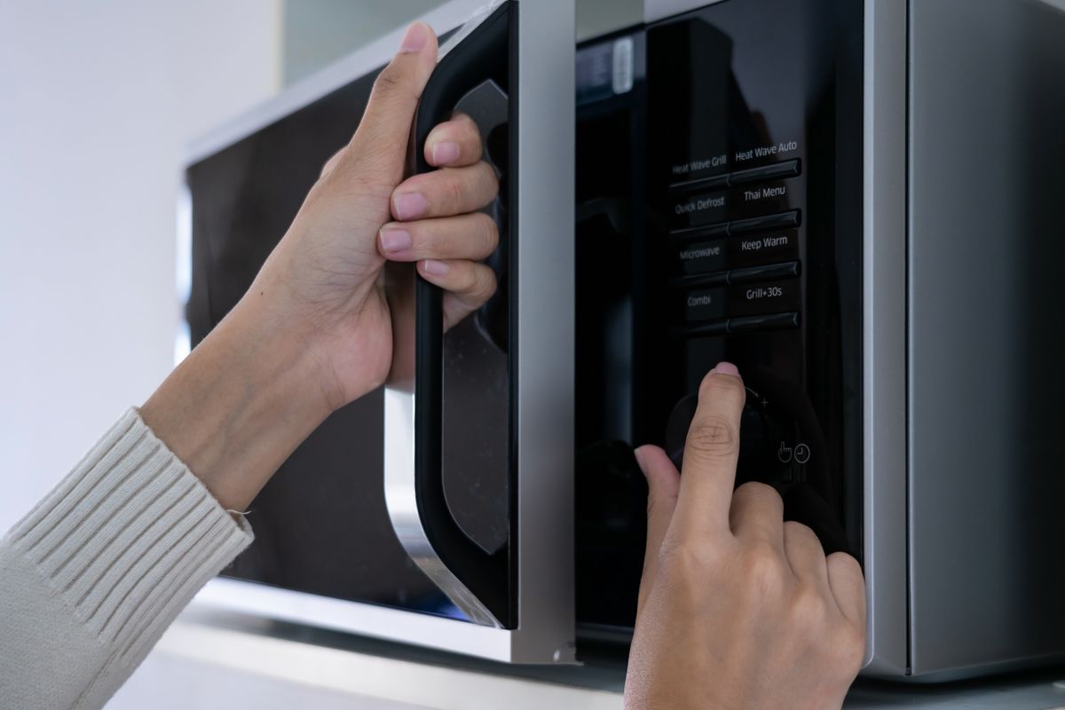 Woman's,Hands,Closing,The,Microwave,Oven,Door,And,Preparing,Food