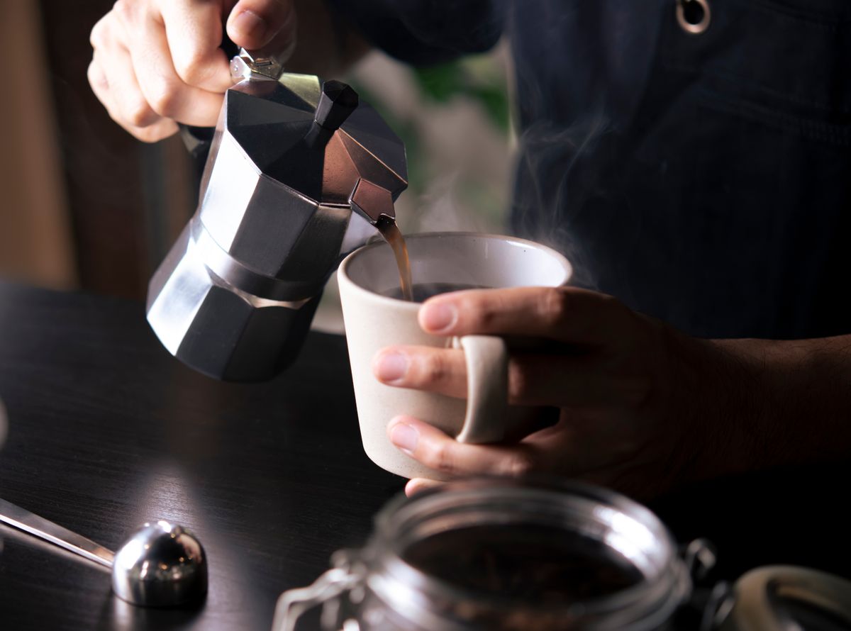 Barista,Pouring,Coffee,From,Moka,Pot,Coffee,Maker,To,A