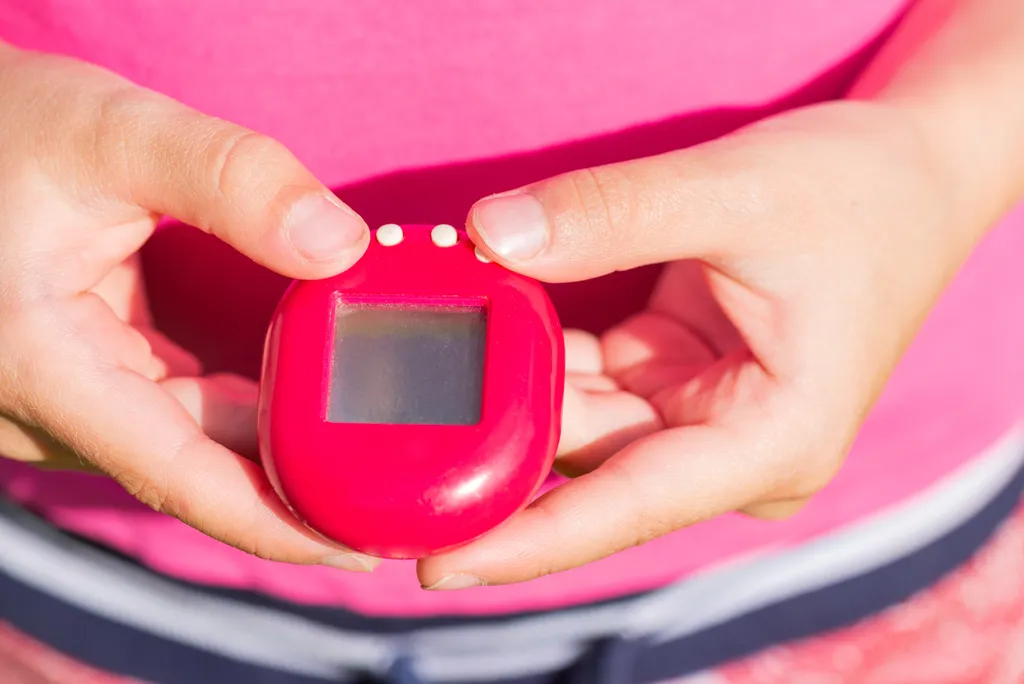 Child,Plays,With,A,Tamagotchi,Toy,,Popular,Game,,Caring,For