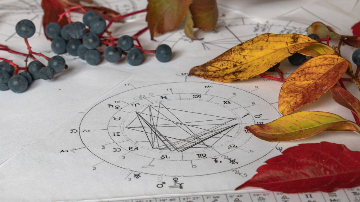 Printed,Astrology,Charts,With,Yelow,And,Autumn,Leaves,And,Blueberries