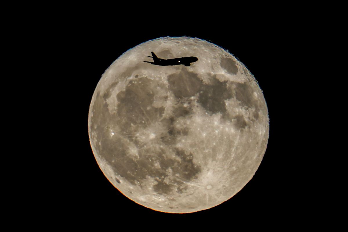 An,Airplane,Flies,Past,The,Supermoon,Known,As,“buck,Moon”,