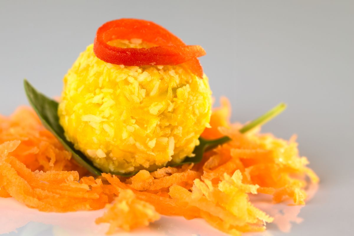 Pumpkin,Coconut,Ball,Garnished,With,A,Red,Pepper,Slice,Served