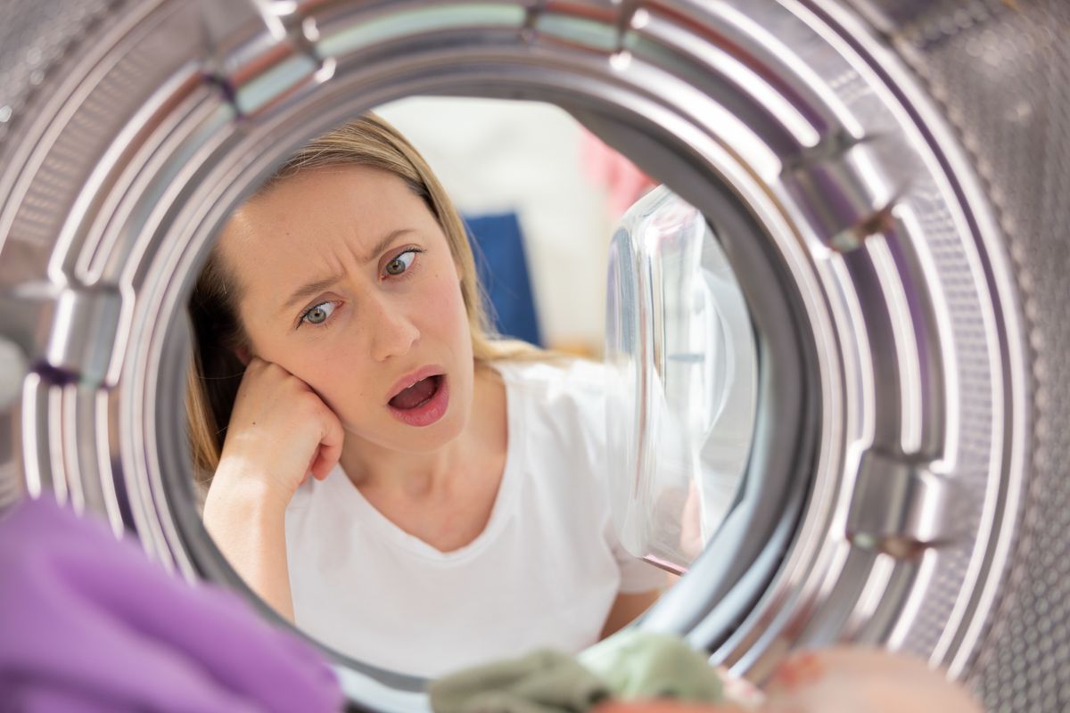 Shocked,Woman,Looks,Into,The,Drum,Of,The,Washing,Machine,