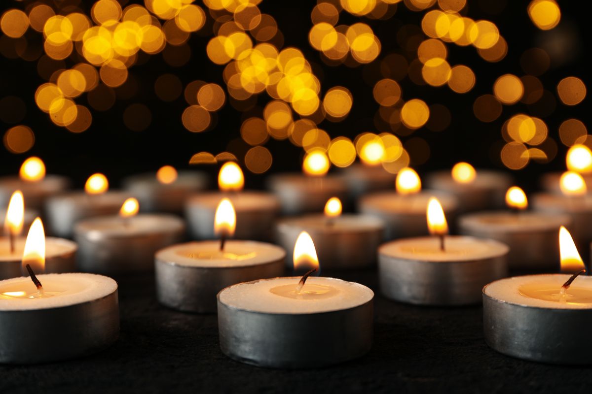 Burning,Small,Candles,On,Black,Background,,Close,Up