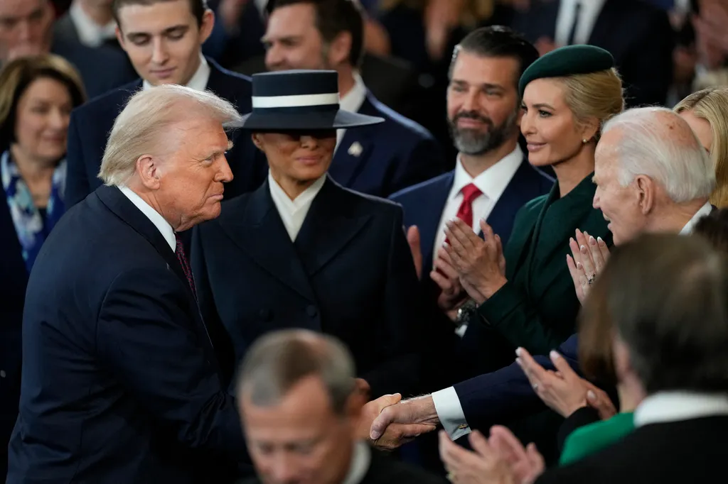 US President Donald Trump shakes hands with former president Joe Biden as First Lady Melania Trump looks on
after he was sworn in as the 47th US President in the US Capitol Rotunda in Washington, DC, on January 20, 2025. (Photo by Julia Demaree Nikhinson / AFP)
