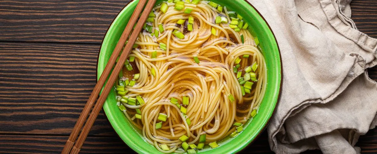 Asian,Noodles,Soup,In,Green,Rustic,Ceramic,Bowl,With,Wooden