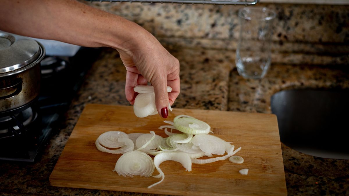 Hagymacsipsz Hand,Holding,Sliced,Onions,On,A,Cutting,Board.,Food,Seasoning.