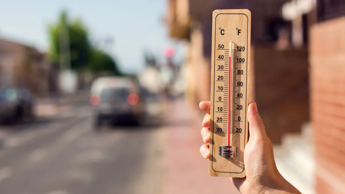 Hot,Weather.,Thermometer,In,Hand,In,Front,Of,An,Urban