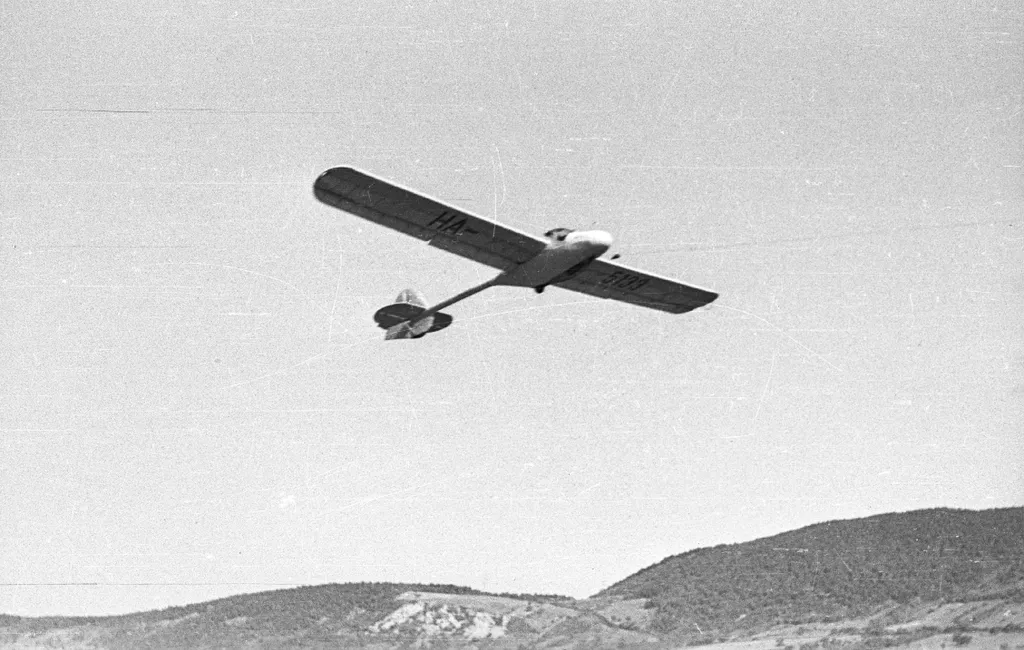 Magyarország,
Budapest II.,
Hármashatárhegyi repülőtér
felszáll egy Rubik R-15 Koma vitorlázó repülőgép, háttérben a Csúcshegy.
Év
1958