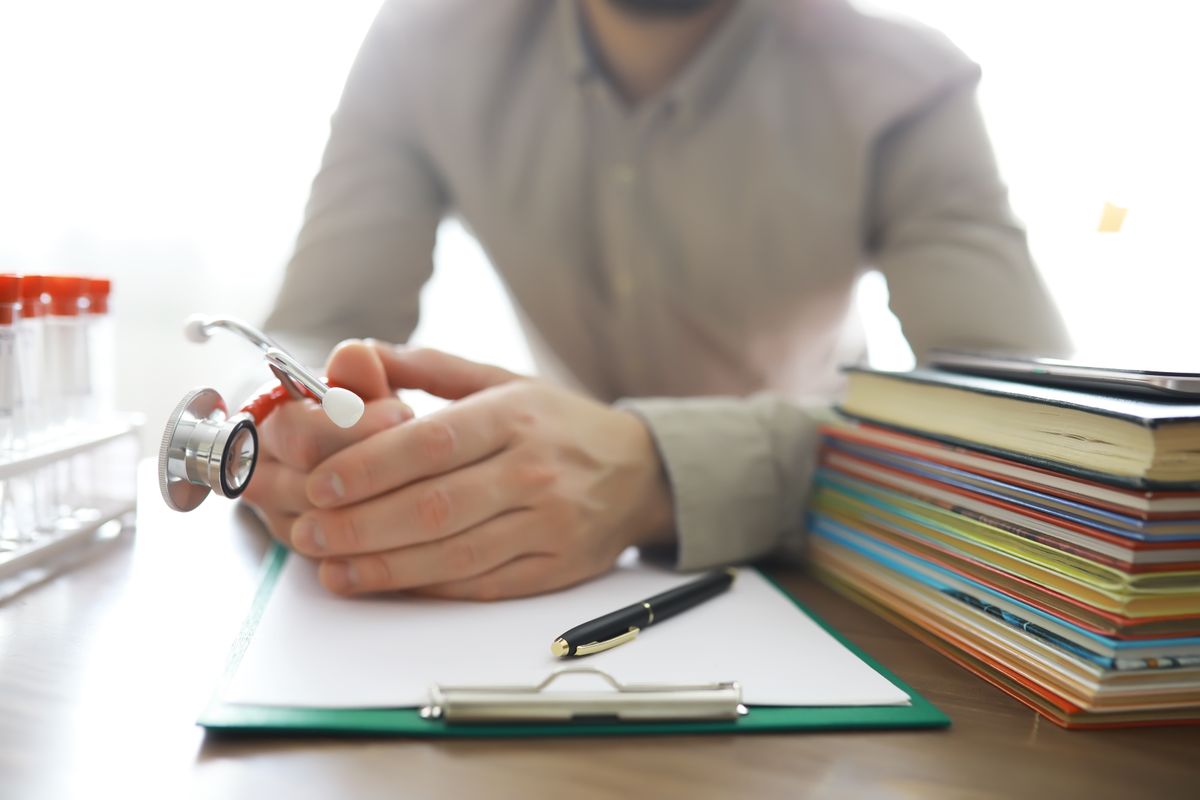Male,Doctor,In,White,Lab,Coat,Reading,Text,Book,,Search