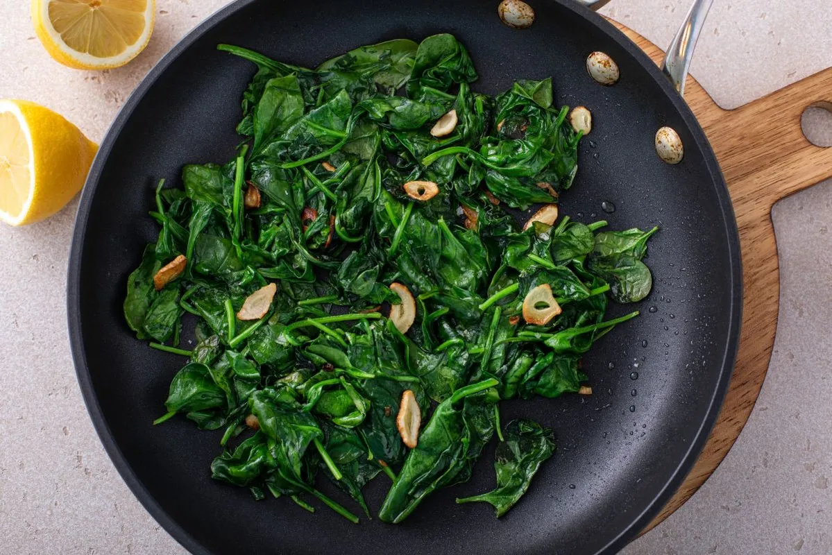 Spenót Sauteed,Garlic,Spinach,In,A,Cooking,Pan,With,Slices,Of